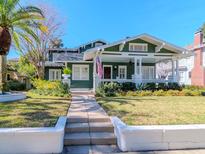 Charming two-story home featuring a large front porch, an American flag, and professionally landscaped yard at 1405 Nance Ave, Tampa, FL 33606