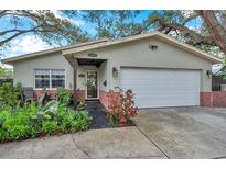 Charming single-story home featuring a well-manicured lawn and a two-car garage at 147 Se Lincoln N Cir, St Petersburg, FL 33703