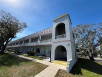 Attractive condo building featuring unique architecture, mature trees, and well-maintained landscaping at 2100 World Parkway Blvd # 56, Clearwater, FL 33763
