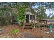 Charming cottage-style home with a screen porch and rustic wooden steps, nestled among lush trees at 3623 Whittier St, Tampa, FL 33619