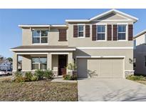 Charming two-story home featuring a two-car garage, neutral stucco, and well-manicured landscaping at 2604 Knight Island Dr, Brandon, FL 33511