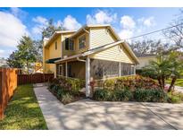 Charming yellow two-story home with a screened in porch and lovely landscaping at 3203 W San Carlos St, Tampa, FL 33629