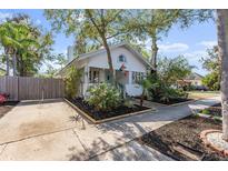 Charming white bungalow with mature landscaping, inviting curb appeal, and concrete driveway at 468 11Th N Ave, St Petersburg, FL 33701