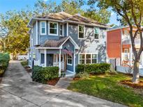 Two-story gray house with a white door, landscaping, and a driveway at 5714 S 1St St, Tampa, FL 33611