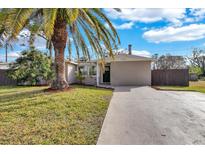 Charming single-story home featuring a well-maintained lawn and complemented by a mature palm tree at 6706 Sierra Ter, New Port Richey, FL 34652