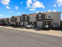 Beautiful townhome exterior featuring a neat gray facade, attached garages, and well-kept landscaping on a sunny day at 8617 Falling Blue Pl, Riverview, FL 33578