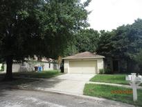 Charming single-story home with a two-car garage and mature landscaping providing ample shade at 11818 Mango Groves Blvd, Seffner, FL 33584