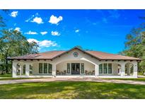 Beautiful single-story home with a wide front porch, brick driveway, and lush green lawn at 17630 Brown Rd, Odessa, FL 33556