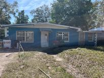 Exterior of a single-story home with a blue exterior and a yard in need of landscaping at 1911 E Noel St, Tampa, FL 33610