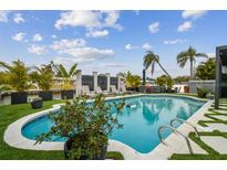 A stunning backyard oasis featuring a sparkling pool, lush landscaping, and lounge chairs for ultimate relaxation at 3934 Doral Dr, Tampa, FL 33634