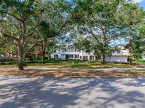 Charming two-story white home with black shutters, mature trees, and a well-manicured lawn at 5001 S Shore Crest Cir, Tampa, FL 33609