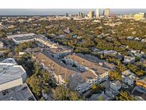 Scenic aerial view of a condo complex with a pool, surrounded by lush trees and city buildings at 800 S Dakota Ave # 205, Tampa, FL 33606