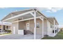 Beige home featuring a covered parking area and white trim at 8448 Fantasia Park Way, Riverview, FL 33578