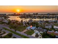 Stunning aerial view of a waterfront community at sunset at 10100 Paradise Blvd, Treasure Island, FL 33706