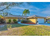 Charming single-story home with well-manicured lawn, mature trees, and a welcoming entryway at 12478 93Rd Way, Largo, FL 33773