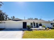 Charming single-story home with a well-manicured lawn and a welcoming front porch at 13290 75Th Ave, Seminole, FL 33776