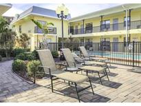 Relaxing courtyard featuring lounge chairs, beautiful landscaping, and a view of the condo building at 16333 Gulf Blvd # 105, St Petersburg, FL 33708