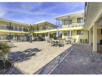 Community patio with tables and chairs near the pool at 16333 Gulf Blvd # 106, St Petersburg, FL 33708