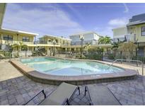 Community pool with lounge chairs and secure fencing, perfect for relaxation at 16333 Gulf Blvd # 108, St Petersburg, FL 33708