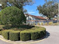 Landscaped entrance to The Villas of Lake Air community with decorative shrubs and mature trees at 2070 Lakeview Dr # 206, Clearwater, FL 33763