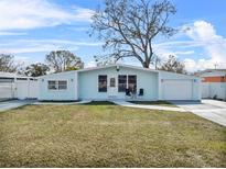 Charming single-story home with a well-manicured lawn, a quaint front porch, and a light blue facade at 4414 W Paris St, Tampa, FL 33614