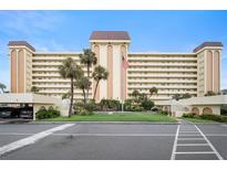 Multi-story building showcasing manicured landscaping with palm trees and visible parking areas at 4725 Cove Cir # 202, St Petersburg, FL 33708