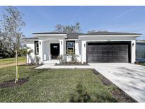 Beautiful single-story home with a black garage door, minimalist landscaping, and a freshly painted white exterior at 5885 114Th N Ter, Pinellas Park, FL 33782