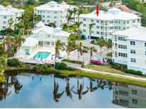 An aerial view of the Condo community, featuring a pool, lush landscaping, and water views at 7611 34Th W Ave # 303, Bradenton, FL 34209