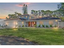 Two-story house with white exterior, updated landscaping, and a two-car garage at 2506 Madrid Way S, St Petersburg, FL 33712