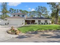 Stunning two-story home, white exterior, nicely landscaped lawn, and a two-car garage at 2506 Madrid Way S, St Petersburg, FL 33712