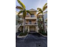 Charming townhouse with a two-car garage and multiple balconies surrounded by lush tropical landscaping and mature palm trees at 3244 Mangrove Point Dr, Ruskin, FL 33570