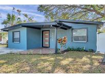 Cute bungalow with a freshly painted exterior, modern door, and landscaping at 4412 W Pearl Ave, Tampa, FL 33611