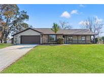 Charming single-story home featuring a brick facade, attached garage, and well-manicured lawn at 4472 Bayridge Ct, Spring Hill, FL 34606