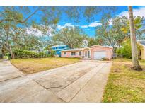 Charming single-story home featuring a well-maintained lawn and a long driveway at 4636 W Longfellow Ave, Tampa, FL 33629