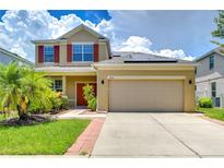 Two-story house with solar panels and a two-car garage at 5365 Shasta Daisy Pl, Land O Lakes, FL 34639