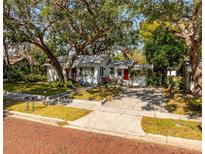 Charming single-story home with a well-manicured lawn and mature trees providing shade at 620 Scotland St, Dunedin, FL 34698