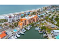 Stunning aerial view of the building, beach, and marina, showcasing the desirable coastal location at 13235 Gulf Blvd # 306, Madeira Beach, FL 33708