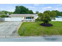 Charming single-story home with well-manicured lawn, mature tree, and white picket fence at 1560 Bel Keene Dr, Clearwater, FL 33756