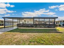 Charming single-story home with a covered carport, screened-in porch, and well-maintained front yard at 36852 Kimela Ave, Zephyrhills, FL 33542