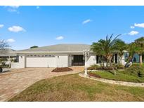 Charming single-story home with a brick driveway, two-car garage, and beautiful landscaping at 6322 Cottonwood Ln, Apollo Beach, FL 33572