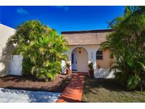 Charming single-story home featuring a beautifully landscaped front yard, tiled roof, and inviting walkway at 9987 85Th Way, Seminole, FL 33777