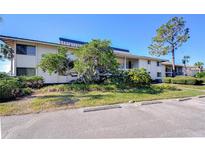 Inviting two-story condominium complex featuring a parking area and lush landscaping at 29230 Bay Hollow Dr # 3274, Wesley Chapel, FL 33543