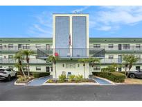 Condo building with manicured landscaping, palm trees and a welcoming entrance at 5973 Terrace Park N Dr # 311, St Petersburg, FL 33709
