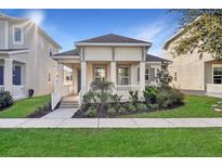 Charming home features a landscaped front yard and a covered front porch with white columns and railings at 724 Winterside Dr, Apollo Beach, FL 33572