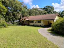 Charming single-story home with a well-manicured lawn and a long driveway at 7608 Chenkin, Zephyrhills, FL 33540