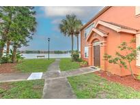 Charming home with a lakeside view, lush landscaping, and inviting walkway to the front door at 9204 Lake Chase Island Way # 9204, Tampa, FL 33626