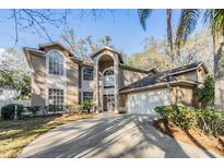 Two story home featuring an arched entryway, large windows, a two car garage and manicured landscaping at 9318 Heritage Oak Ct, Tampa, FL 33647