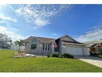 Charming single-story home boasts a manicured lawn and attached two-car garage at 3600 105Th N Ave, Clearwater, FL 33762