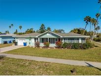 Charming single-story home with a well-manicured lawn and a red front door at 66 Kipling Plz, Clearwater Beach, FL 33767