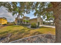 Inviting home featuring a well-manicured lawn, mature trees, and a spacious three-car garage at 918 Regal Manor Way, Sun City Center, FL 33573